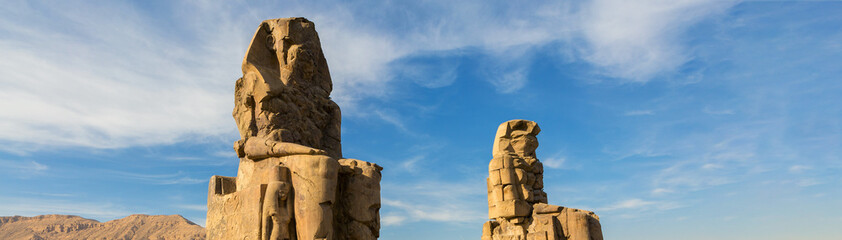 Colossi of Memnon Luxor Thebes against the background of dawn in the Egypt