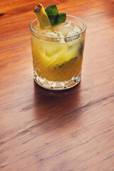 Fruit mixology on wooden table. Warm colored cocktails. Vertical shot.