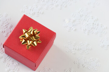 Small red gift box with gold decor and fake snow on a white background. Isolated.Copy space. top view.