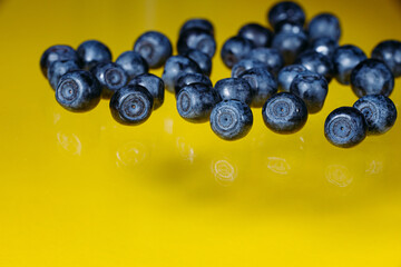 Group of fresh juicy blueberries isolated on a yellow background
