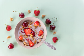 Obraz na płótnie Canvas bowl of muesli and yogurt with fresh cherries, strawberries.diet breakfast - bowls of oat flake, berries and fresh milk on green background. health and diet concept