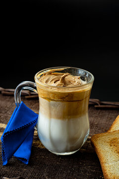 
Dalgona coffee in glass cup with blue napkin and toast