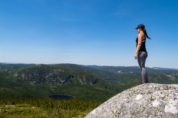 Naklejka na ściany i meble Young woman admiring the landscape at the top of the 