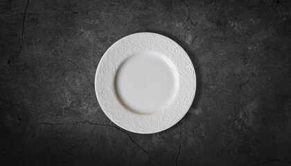 white plate on a dark gray background stone table top view