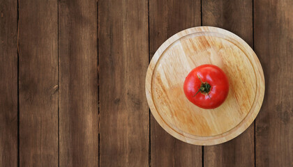 wooden round cutting Board plate on a wooden surface table top view red ripe tomato