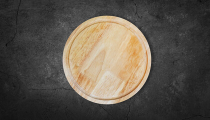 wooden round cutting Board plate on a dark gray stone cement surface table top view kitchen