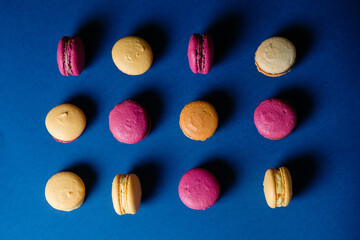Macarons pattern on blue background. Colorful french desserts. Top view.