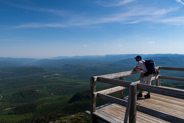 Hiker admiring the beautiful view from the top of the mont-du-lac-des-cygnes (Swan lake mountain) in Charlevoix, Quebec