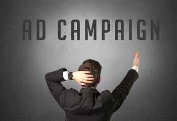 Rear view of a businessman with AD CAMPAIGN inscription, powerfull business concept