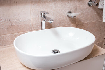 The snow-white shining sink, bathroom equipment in the apartment, hotel