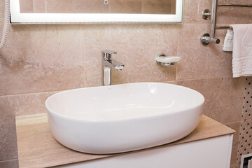 The snow-white shining sink, bathroom equipment in the apartment, hotel