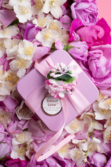 box with gift  around roses  and  jasmine background. romantic and beauty concept