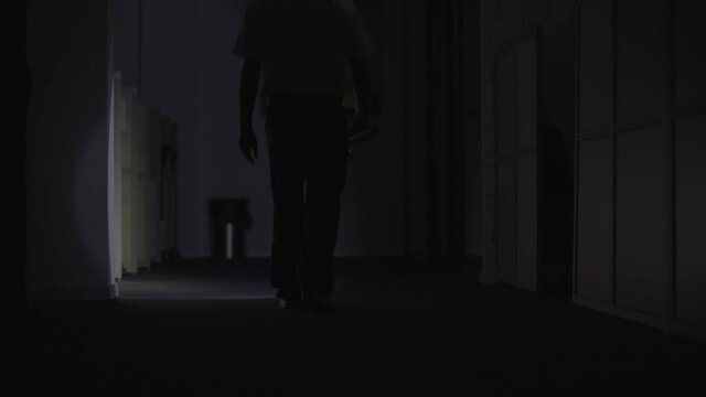 Security Guard makes a detour In Corridor Of The Building Using Flashlight. High-quality 4k footage.