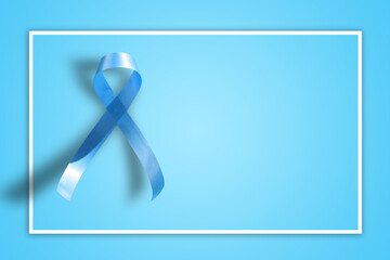 blue ribbon on blue background representing an annual event during the month of November to raise awareness of men's health issues and prostate cancer with copy space