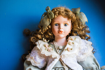 Porcelain doll face on blue background