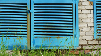 metal blue door grating summer white brick wall green grass