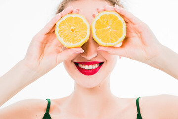 Emotional portrait of a girl with lemons in hands on an isolated white background. The concept of a healthy diet, healthy lifestyle and vegetarianism