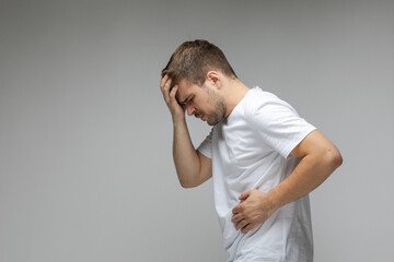 The young guy has severe abdominal pain. Guy holds his stomach