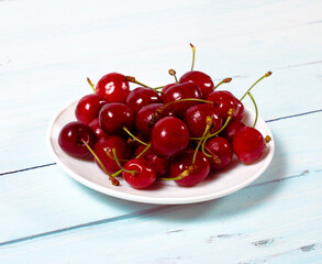 Fototapeta na wymiar close-up of Cherry freshly picked from the garden washed with water droplets on a white saucer