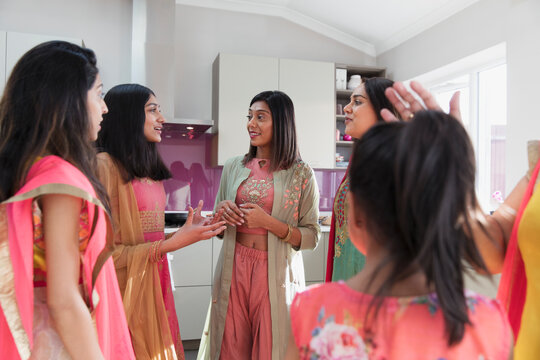 Indian women in saris taking in kitchen
