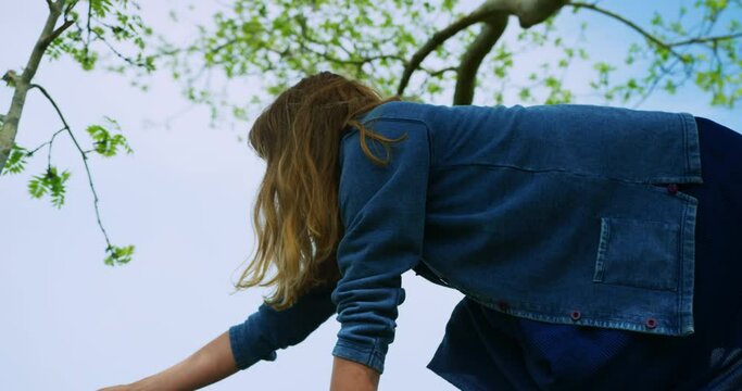 Pregnant woman climbing a big tree