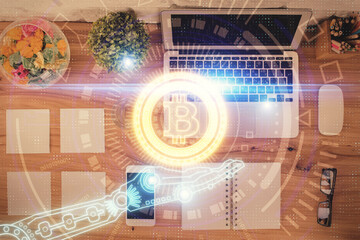 Blockchain theme hologram drawings over computer on the desktop background. Top view. Double...