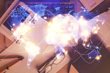 Double exposure of business theme hologram over desktop with phone. Top view. Mobile international trade connection concept.