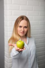 Beautiful white girl Bank employee shows an Apple. Effective diet.