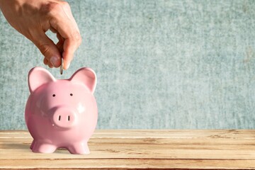 Businessman putting coin into the piggy bank