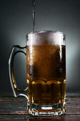 beer mug with foam on a wooden board
