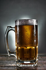 beer mug with foam on a wooden board