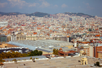 Panoramic view of sunny Barcelona in Spain. Roofs of the houses and mountains. High quality photo