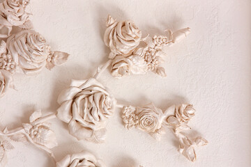 Ceramic roses on the wall with venetian stucco. Tenderness and beauty in a stone product