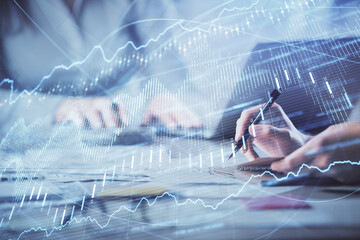 Multi exposure of woman hands typing on computer and financial chart hologram drawing. Stock market...