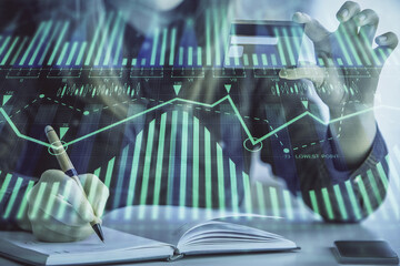 Double exposure of woman on-line shopping holding a credit card and data theme hologram drawing. E-commerce concept.