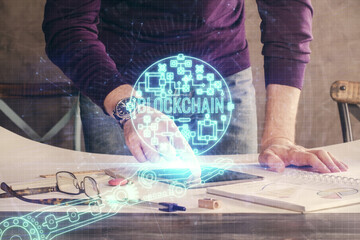 Double exposure of man's hands holding and using a phone and crypto currency blockchain theme drawing.