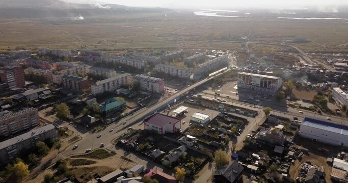Aerial view of the city of Ulan-Ude. Russia Siberia. Rivers, apartment buildings, highway, busy traffic, hills, smoke, foggy weather. 4K