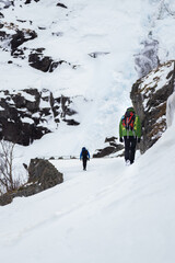 Hikers in winter on Trollstigen is Norway’s most visited tourist road 