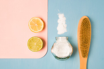 lemon, lime, sprinkled soda, a jar of soda and a wooden brush for cleaning on a blue background, eco-friendly non-toxic home cleaning products, zero waste lifestyle, top view copy space