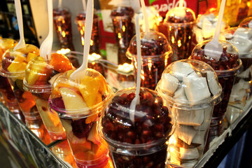 Sliced fruit in clear plastic cups at a market in Jerusalem. Fruit mixture in a glass.