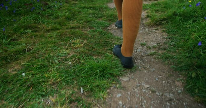 Feet and legs of young woman walkingin naature
