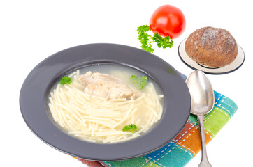 Chicken stock with slice of meat and noodles in black plate.