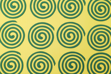 黄色の背景に置いた渦巻の蚊取り線香