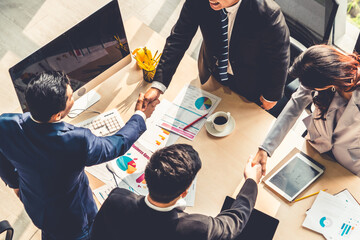 Group business people handshake at meeting table in office together with confident shot from top...