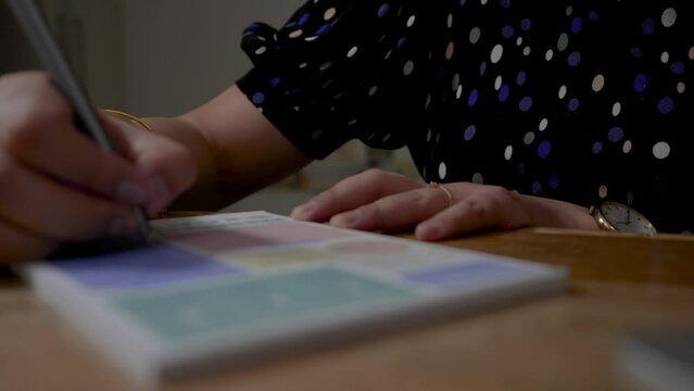Person writing his notes in a notebook