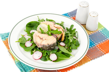 Canned fish with greens on plate isolated on white