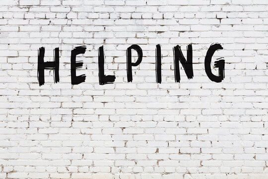 White wall with black paint inscription helping on it