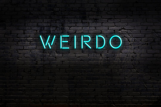 Neon sign. Word weirdo against brick wall. Night view