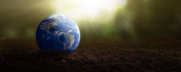planet earth on soil for plants - environmental care concept - Elements of this image furnished by...