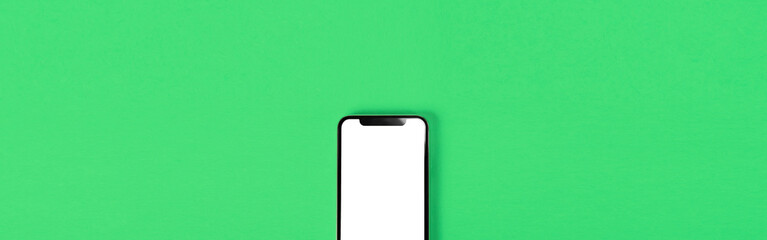 Blank smartphone on green background. Photo.  緑背景の上に置かれたスマホのブランク素材  写真